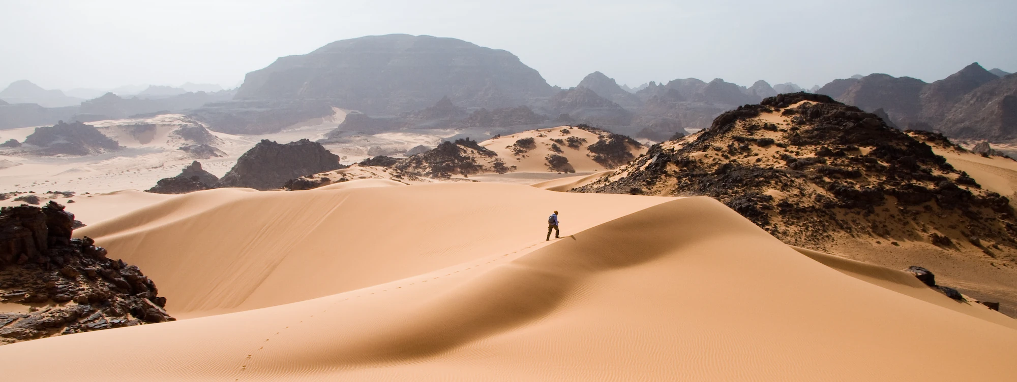 Un uomo che cammina nel deserto.