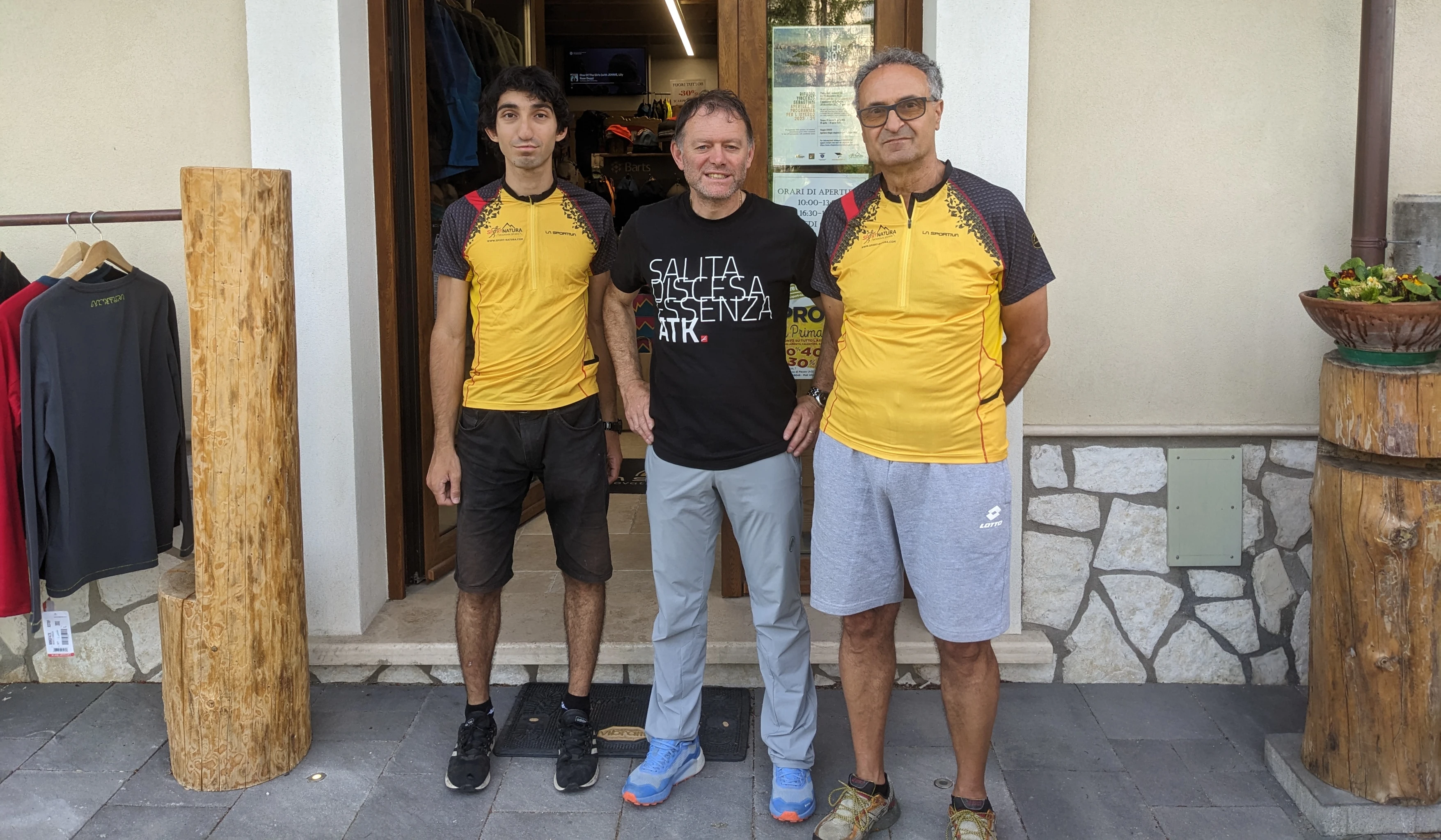 Carlo e Alberto Scalzini davanti al negozio Sport Natura insieme al suo proprietario.